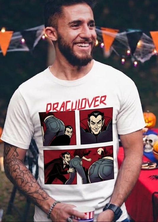 White t-shirt featuring a red "DRACULOVER" title above a 4-panel comic graphic of a vampire biting a woman wearing blue jeans.