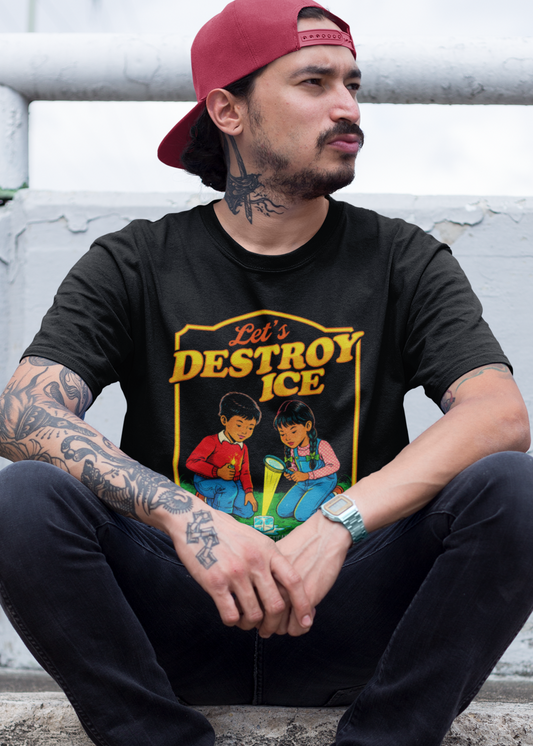 A man wearing a black t-shirt with a vintage-style illustration of a boy and a girl melting an ice cube and the phrase “Let’s Destroy ICE” in bold retro typography.