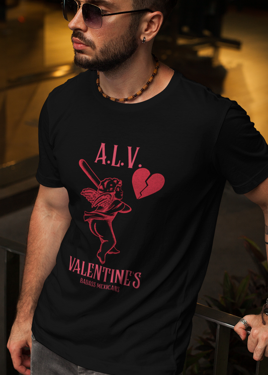 A man wearing a black unisex t-shirt that features a red cherub graphic holding a bat, a broken heart icon, and the text “A.L.V. Valentine’s Badass Mexicans,” inspired by sarcastic Mexican Valentine’s Day humor.