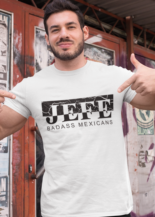A white crew-neck t-shirt showcasing a bold black graphic design centered on the chest. The design features the word "JEFE" printed in a large, heavy serif font, split horizontally across the middle. The upper half of the letters is set inside a solid black rectangular box that features a white distressed, cracked stone or marble texture. The lower half of the letters extends below the box onto the clean white fabric. Directly underneath the word, "BADASS MEXICANS" is printed in a clean, smaller sans-serif.