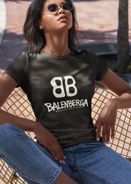 front view of a premium black graphic t-shirt. On the center of the chest, a large white logo features two "B" characters mirrored and interlocked back-to-back. Directly below the logo, the word "BALENBERGA" is printed in an edgy, stylized white paint-stroke font, with "BADASS MEXICANS" cleanly written underneath in a small, minimalist font.