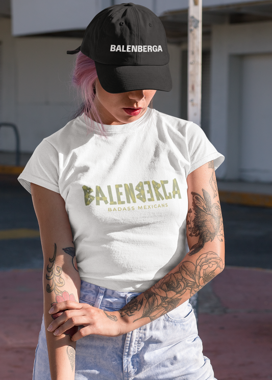 A white streetwear t-shirt showcasing the word "BALENBERGA" across the chest in a heavy, textured, geometric block font with alternating mirrored letters in an olive-beige tone. Underneath, "BADASS MEXICANS" is printed in a clean, sharp matching font.