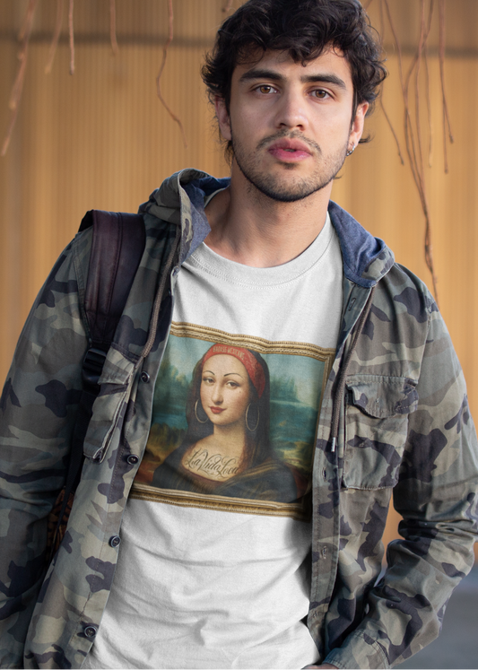 A man wearing a White unisex t-shirt, featuring a parody artwork inspired by the Mona Lisa portrayed with a chola aesthetic, including hoop earrings, a headband, and visible tattoos, framed like a classical painting.