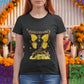 Black fitted women's t-shirt with a Catrina figure featuring yellow butterfly wings and cempasúchil flowers under the text "INOLVIDABLE".