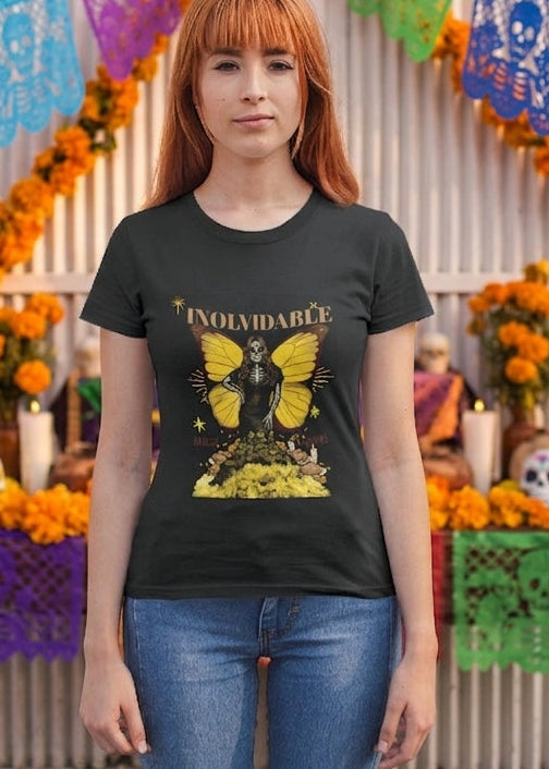 Black fitted women's t-shirt with a Catrina figure featuring yellow butterfly wings and cempasúchil flowers under the text "INOLVIDABLE".
