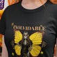 Black fitted women's t-shirt with a Catrina figure featuring yellow butterfly wings and cempasúchil flowers under the text "INOLVIDABLE".