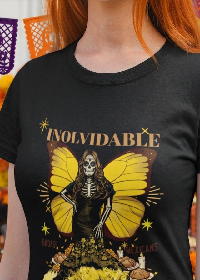 Black fitted women's t-shirt with a Catrina figure featuring yellow butterfly wings and cempasúchil flowers under the text "INOLVIDABLE".