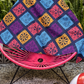 purple papel picado inspired beach towel with colorful skulls suns birds and floral shapes in mexican folk art style