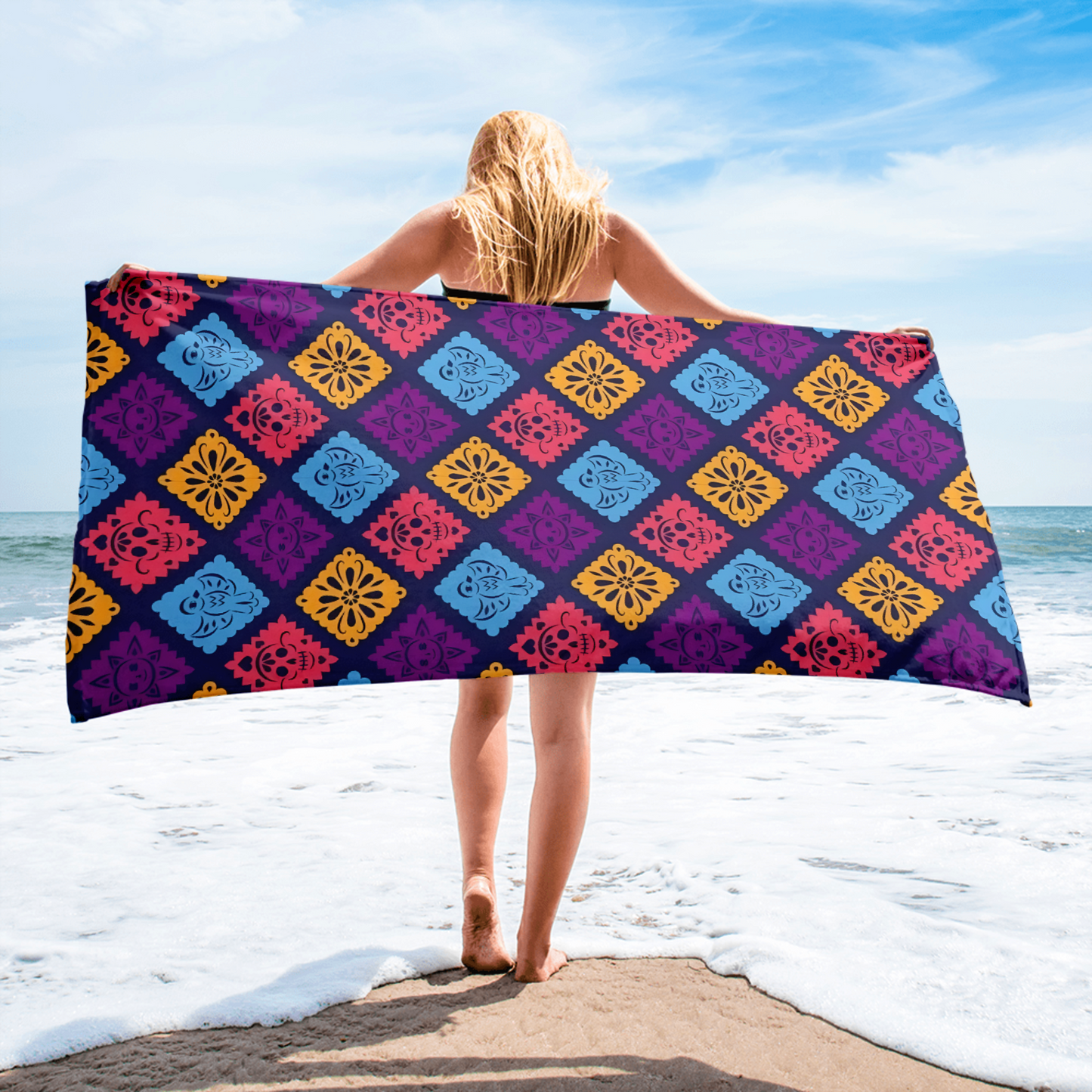 purple papel picado inspired beach towel with colorful skulls suns birds and floral shapes in mexican folk art style