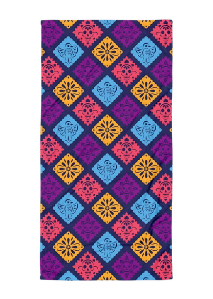 purple papel picado inspired beach towel with colorful skulls suns birds and floral shapes in mexican folk art style