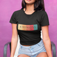 A black fitted women's crew-neck t-shirt featuring a horizontal graphic design across the chest. The design features five vertical, vintage-toned color blocks lined up side-by-side in pastel yellow, soft orange, terracota red, deep pink, and muted teal. Overlaid across these colorful blocks, the word "CHINGONA" is printed in a large, elegant dark gray serif font, with the words "BADASS MEXICANS" written directly underneath in a smaller, clean sans-serif typeface.
