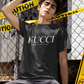 A black lifestyle t-shirt featuring the word "FUCCI" printed in a large, elegant white serif font across the chest. Below it, the brand name "BADASS MEXICANS" is printed in a smaller, clean sans-serif font.