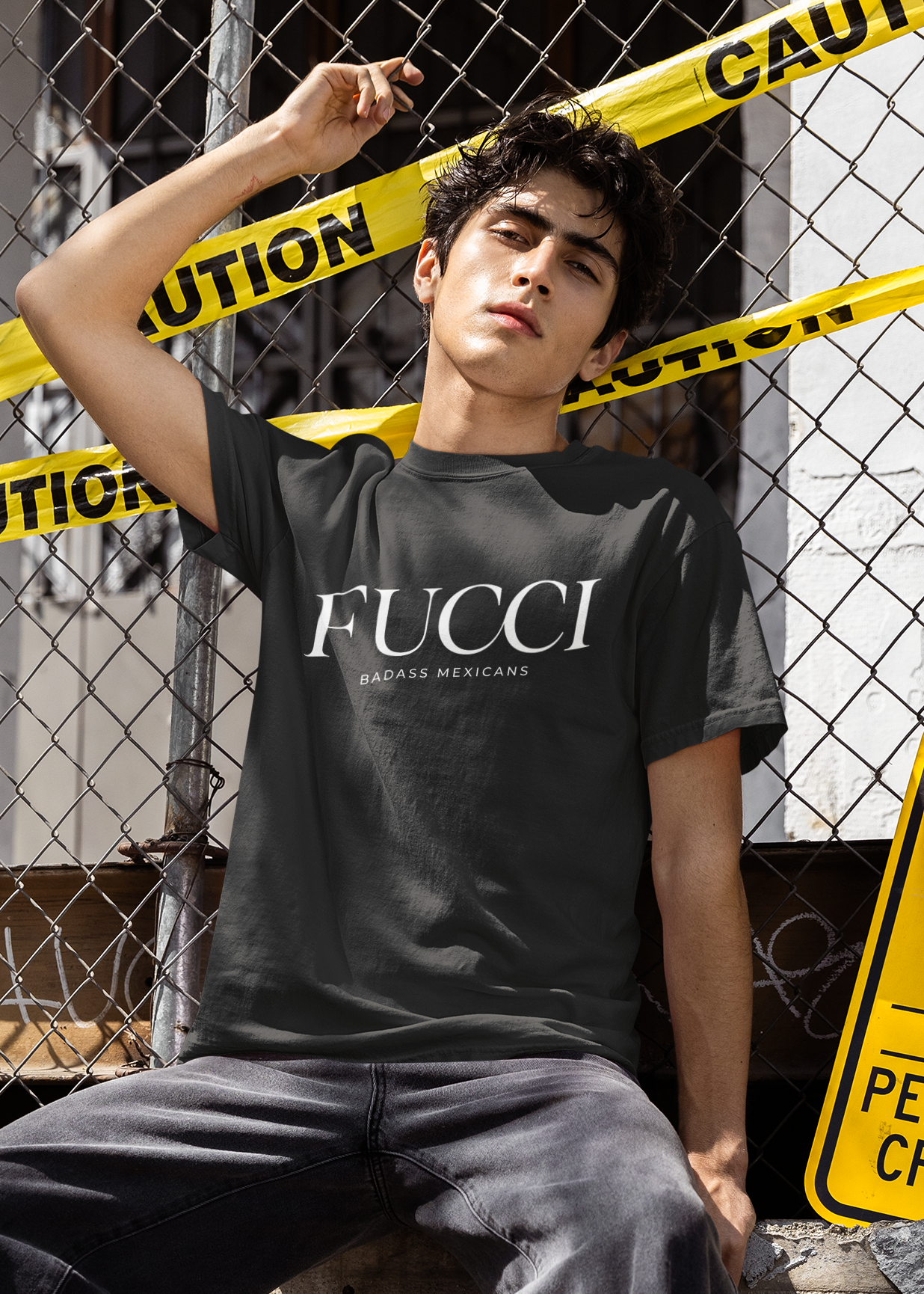 A black lifestyle t-shirt featuring the word "FUCCI" printed in a large, elegant white serif font across the chest. Below it, the brand name "BADASS MEXICANS" is printed in a smaller, clean sans-serif font.