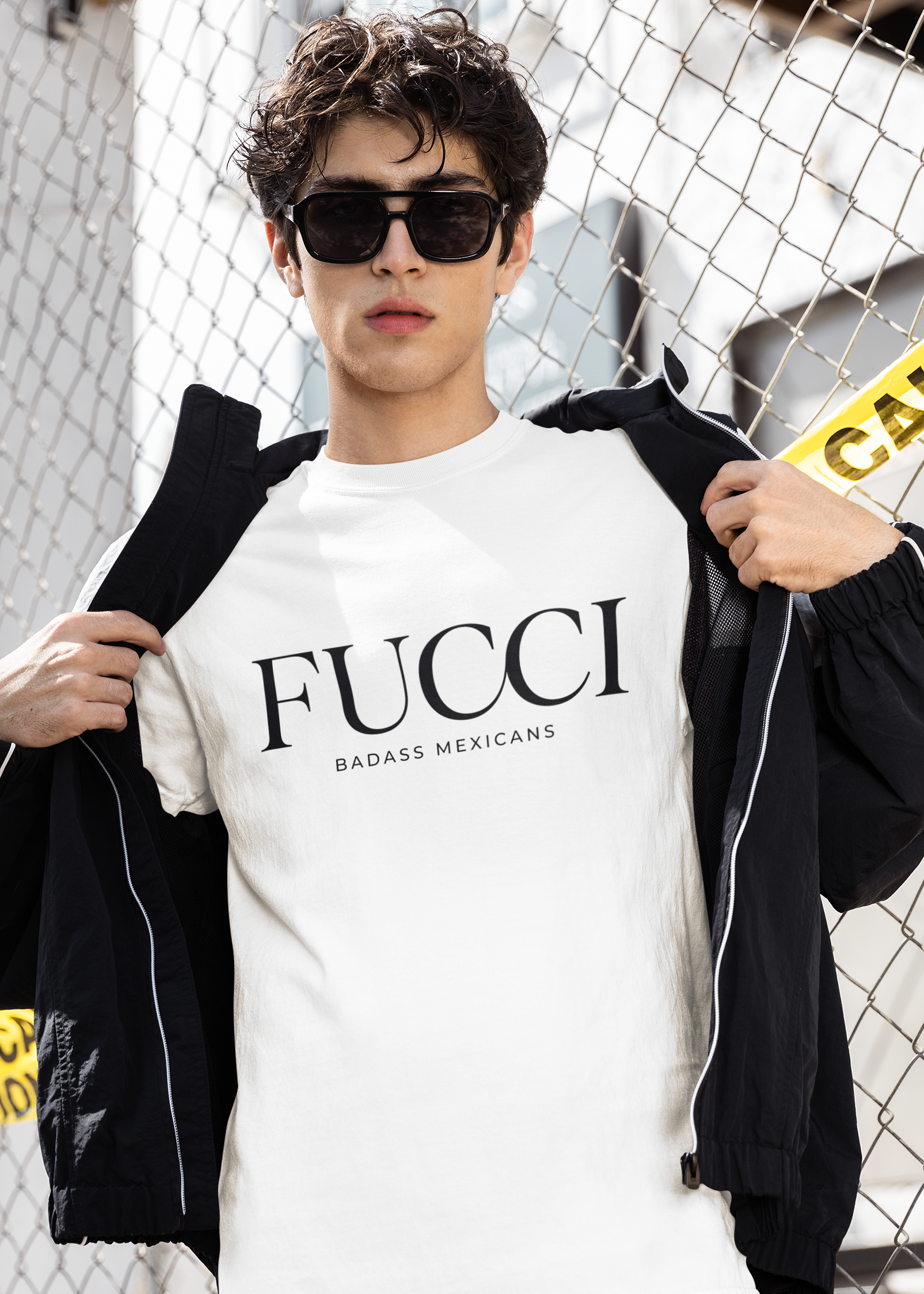 A white lifestyle t-shirt featuring the word "FUCCI" printed in a large, elegant black serif font across the chest. Below it, the brand name "BADASS MEXICANS" is printed in a smaller, clean sans-serif font.