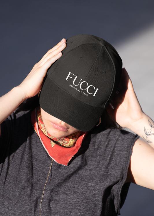 showing a close-up, front-facing view of a classic black dad hat. The word "FUCCI" is prominently embroidered across the front panel in a large, elegant white serif font, with the words "BADASS MEXICANS" stitched right below it in a smaller, clean sans-serif typeface.