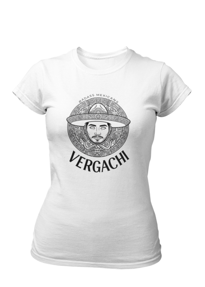 A white t-shirt featuring a large black graphic. The design includes a circular Aztec calendar-style background with a stylized man wearing a traditional Mexican charro hat in the center. The word "VERGACHI" is printed in a bold, arched serif font underneath the graphic, with "BADASS MEXICANS" in a small arch above it.