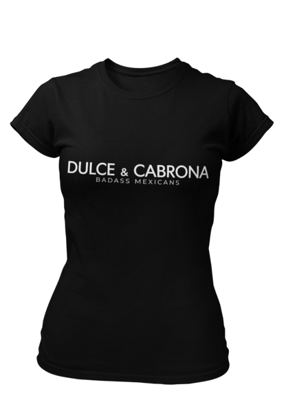 A fitted black women's t-shirt with the words "DULCE & CABRONA" printed in a clean, white luxury-style font. Below the main text, "BADASS MEXICANS" is printed in a smaller, secondary font.