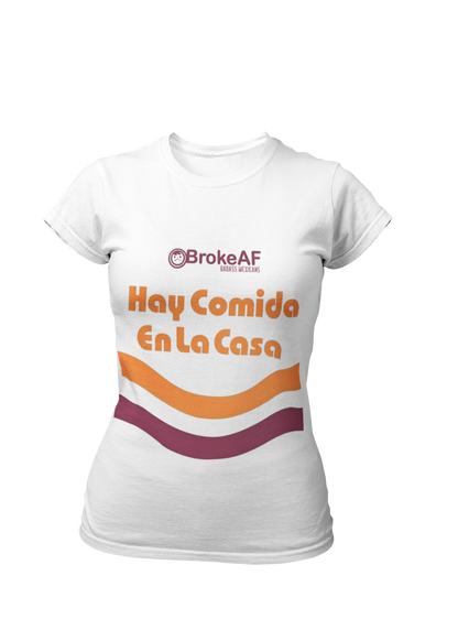 White t-shirt featuring the phrase “Hay Comida En La Casa” in a retro instant noodle-inspired design with orange and brown accents.