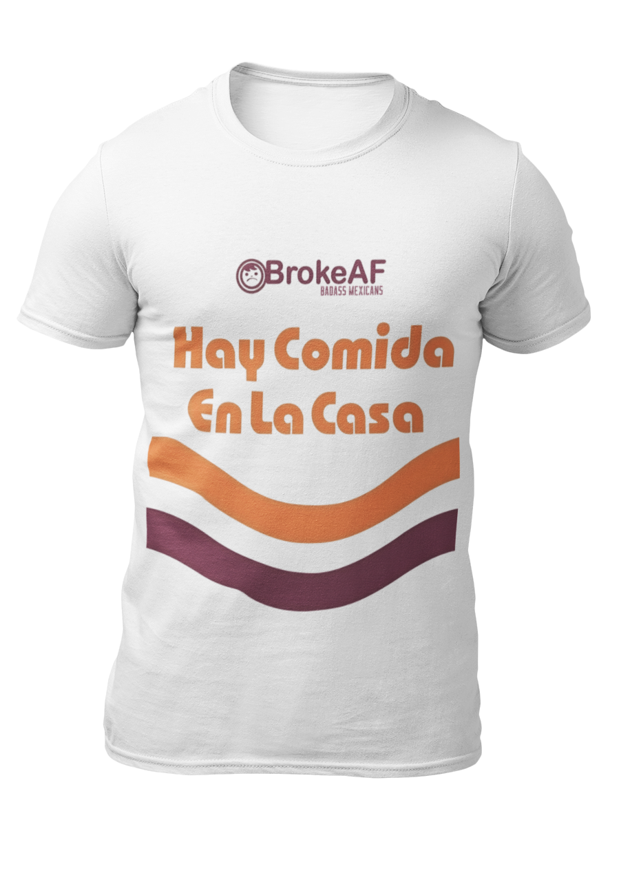 White t-shirt featuring the phrase “Hay Comida En La Casa” in a retro instant noodle-inspired design with orange and brown accents.
