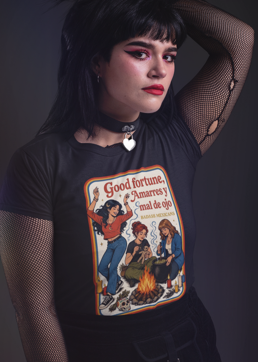 Black fitted t-shirt featuring a retro 70s illustration of three witches around a campfire with the text "Good fortune, Amarres y mal de ojo".