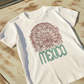 white graphic t-shirt with front print quetzalcoatl inspired mexican design and retro mexico typography