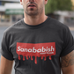A black crew-neck t-shirt featuring a solid red rectangular box graphic on the chest. Inside the box, the word "Sanababish" is printed in a bold white, slanted font, with the words "BADASS MEXICANS" in smaller white letters beneath it. The bottom edge of the red box is styled to look like wet paint, with thick red droplets dripping down onto the fabric.