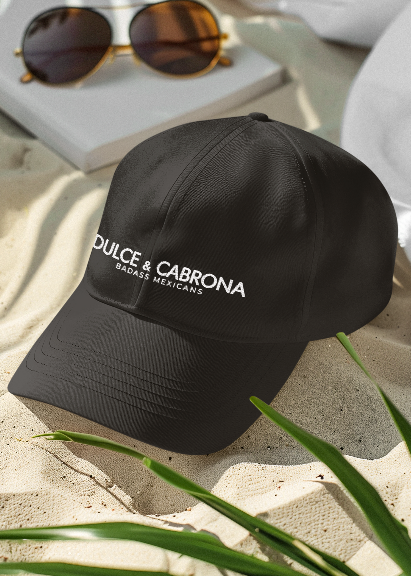 black dad hat On the front panel of the hat, the words "DULCE & CABRONA" are printed in a clean white luxury-style serif font, with "BADASS MEXICANS" printed right underneath in a smaller size.