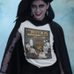 White t-shirt featuring a spooky band parody with ghosts around a fireplace with text reading "LOS BOOOKIS".