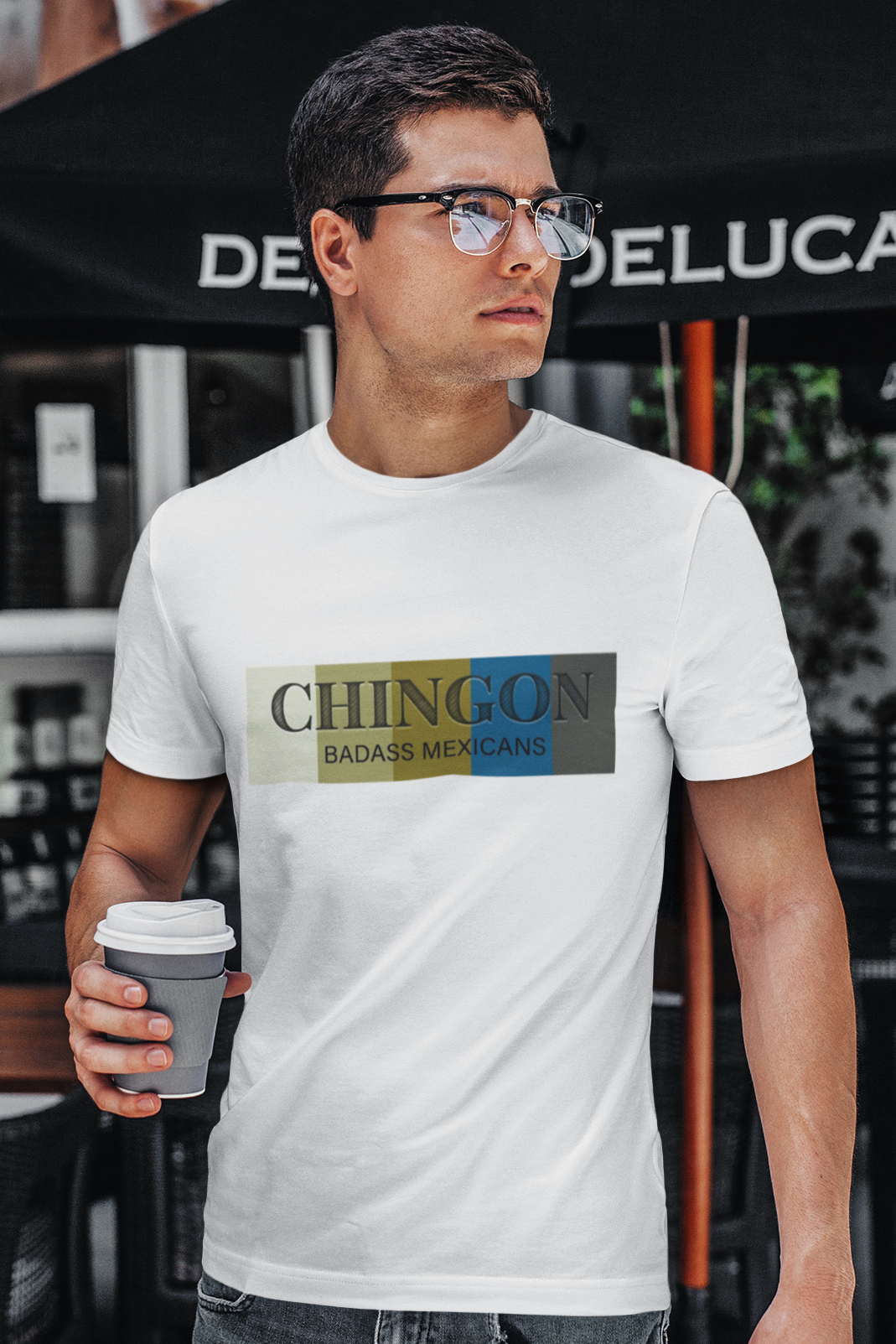 An white crew-neck t-shirt featuring a graphic design printed across the chest. The design consists of five vertical color blocks lined up side-by-side in white, beige, gold, blue, and dark gray. Overlaid on these blocks, the word "CHINGON" is printed in a large, elegant dark gray serif font, with the words "BADASS MEXICANS" written directly underneath in a smaller, clean sans-serif typeface.