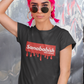 A black crew-neck t-shirt featuring a solid red rectangular box graphic on the chest. Inside the box, the word "Sanababish" is printed in a bold white, slanted font, with the words "BADASS MEXICANS" in smaller white letters beneath it. The bottom edge of the red box is styled to look like wet paint, with thick red droplets dripping down onto the fabric.