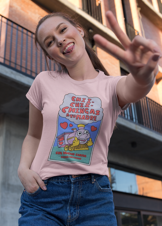 A woman wearing light pink unisex t-shirt featuring a colorful Valentine-style illustration with Spanish text that reads "Chingas a tu Madre" “Con Cariño,” designed as a humorous and playful Mexican-inspired message.