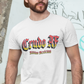 A white crew-neck t-shirt featuring the text "Crudo AF" printed across the chest in a bold, stylized Gothic font. The letters have a horizontal color gradient transition from red at the top, fading into yellow and white at the bottom, outlined in black with a heavy black drop shadow. Directly below, the words "BADASS MEXICANS" are printed in a smaller, matching Gothic font with the same red, yellow, and white gradient and drop shadow effect.