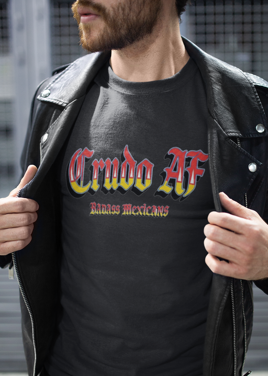 A black crew-neck t-shirt featuring the text "Crudo AF" printed across the chest in a bold, stylized Gothic font. The letters have a horizontal color gradient transition from red at the top, fading into yellow and white at the bottom, outlined in black with a heavy black drop shadow. Directly below, the words "BADASS MEXICANS" are printed in a smaller, matching Gothic font with the same red, yellow, and white gradient and drop shadow effect.