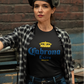 A woman wearing a black t-shirt featuring the phrase “Cabrona Extra” in bold blue lettering with a gold crown above, inspired by a classic beer-style typography.