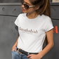 White crew-neck t-shirt with "Sanababish" printed across the chest in a stylized font with a brown textured pattern, and "BADASS MEXICANS" in small black text below.