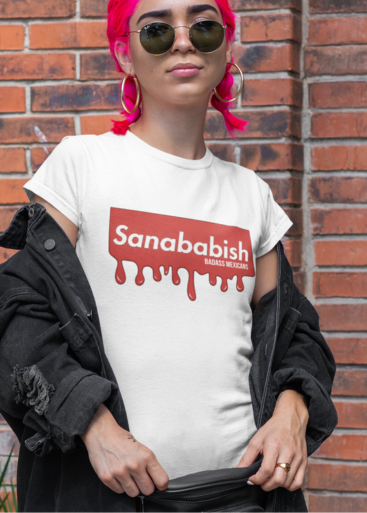 A white crew-neck t-shirt featuring a solid red rectangular box graphic on the chest. Inside the box, the word "Sanababish" is printed in a bold white, slanted font, with the words "BADASS MEXICANS" in smaller white letters beneath it. The bottom edge of the red box is styled to look like wet paint, with thick red droplets dripping down onto the fabric.