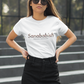 White crew-neck t-shirt with "Sanababish" printed across the chest in a stylized font with a bricks textured pattern, and "BADASS MEXICANS" in small black text below.