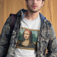 A man wearing a White unisex t-shirt, featuring a parody artwork inspired by the Mona Lisa portrayed with a chola aesthetic, including hoop earrings, a headband, and visible tattoos, framed like a classical painting.