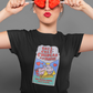 Woman wearing black t-shirt featuring a colorful Valentine-style illustration with Spanish text that reads "Chingas a tu Madre" “Con Cariño,” designed as a humorous and playful Mexican-inspired message.